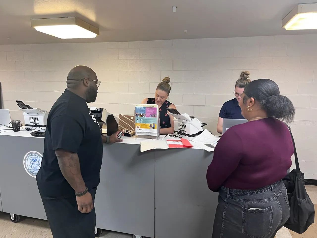 A group of people standing around a counter.