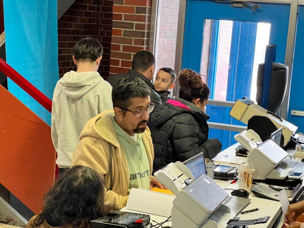 Group at table with electronic devices near entrance