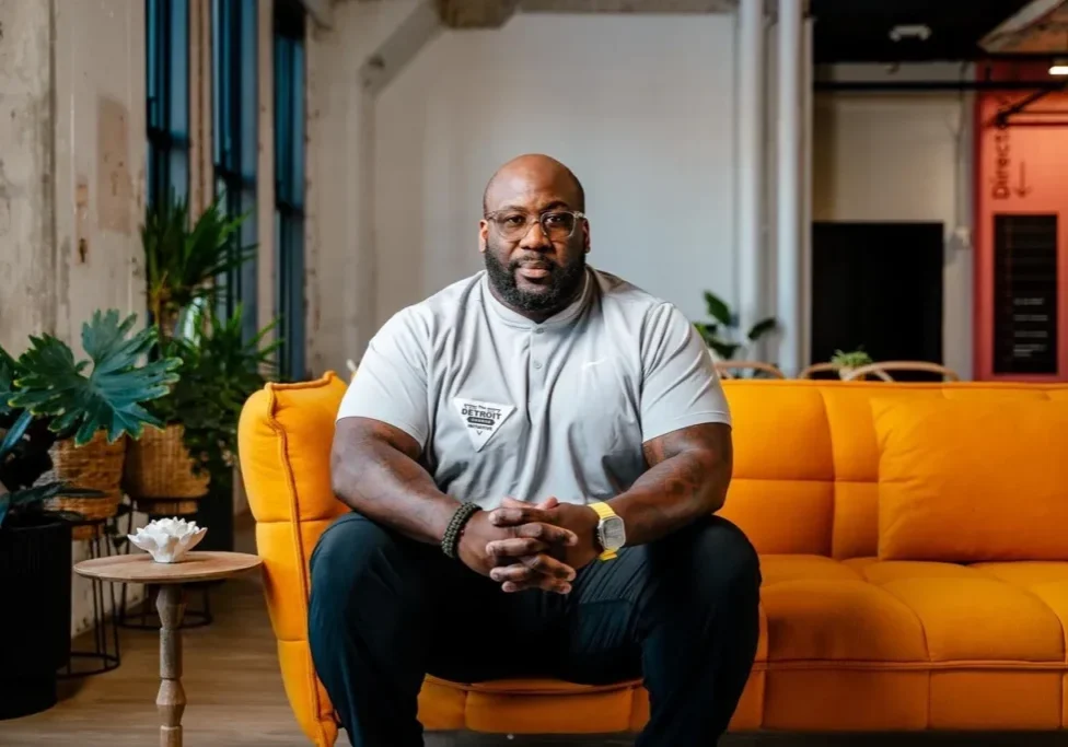 A man sitting on top of a yellow couch.
